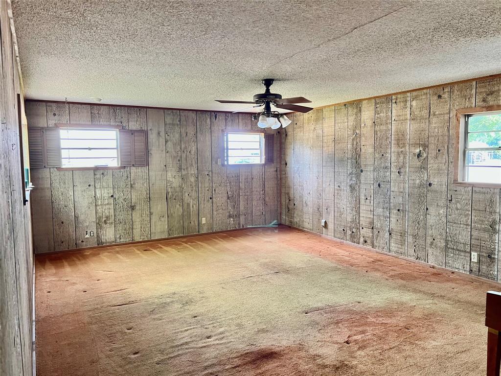 200 Dallas Street Nocona, TX 76255 - Photo 14 of 29 en empty room with windows and fan