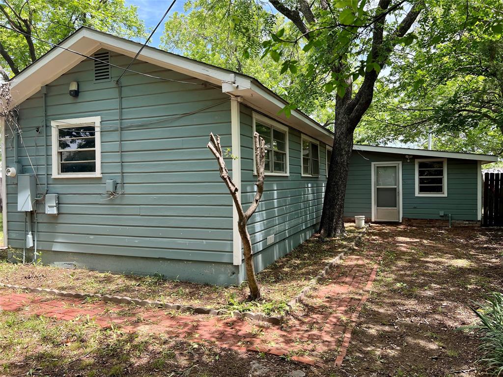200 Dallas Street Nocona, TX 76255 - Photo 18 of 29 a view of a house with a yard tree and wooden fence