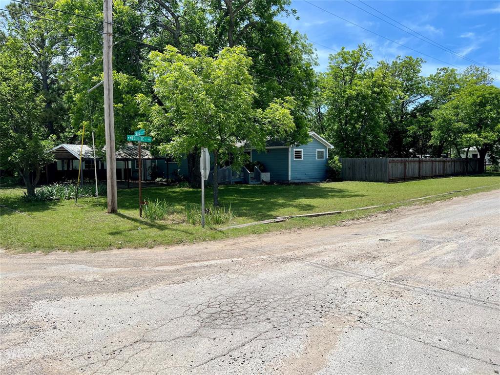 200 Dallas Street Nocona, TX 76255 - Photo 20 of 29 a house with a yard and a large tree