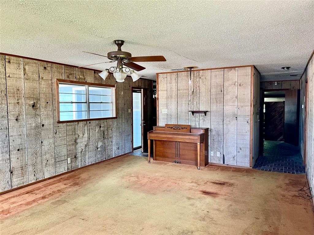 200 Dallas Street Nocona, TX 76255 - Photo 3 of 29 a room with a chandelier fan and windows