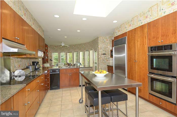 913 Poplar Hill Road Baltimore, MD 21210 - Photo 12 of 21 a kitchen with a table chairs microwave and stove top oven