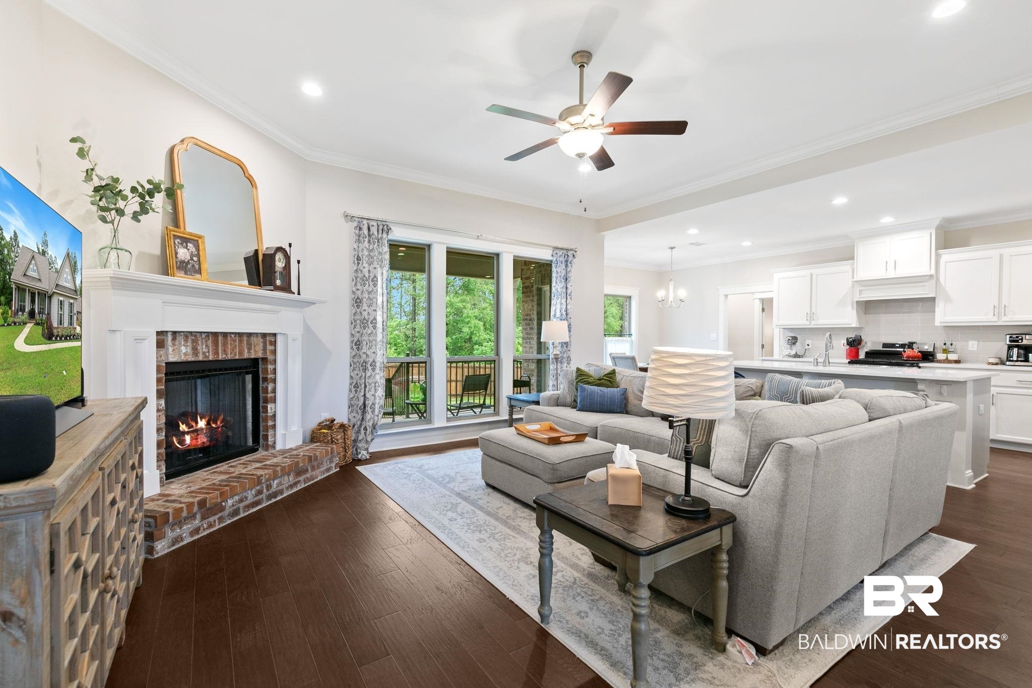 13233 Ibis Boulevard Daphne, AL 36527 - Photo 6 of 100 Open-concept living space featuring wood-finish flooring, a brick fireplace with a white mantel, and a ceiling fan