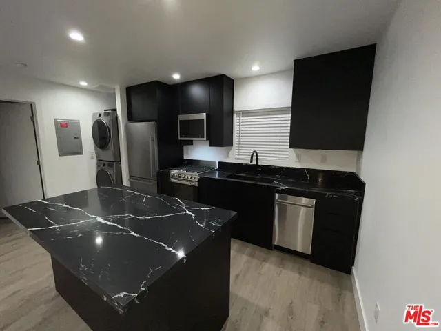 a kitchen with a sink and a stove top oven with wooden floor
