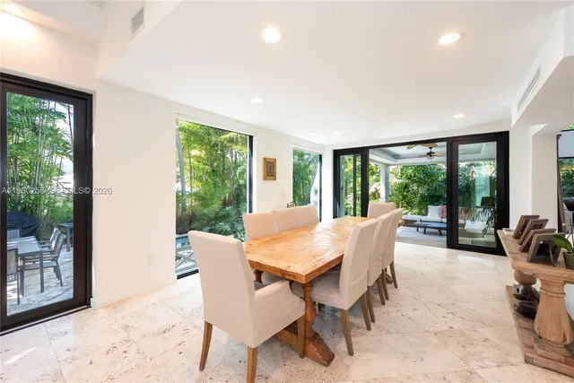 a dining room with furniture and large windows