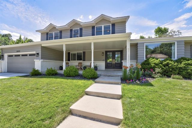 a front view of a house with a yard and potted plants