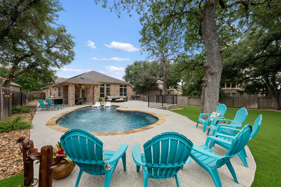 a view of a patio with table and chairs potted plants and a large tree