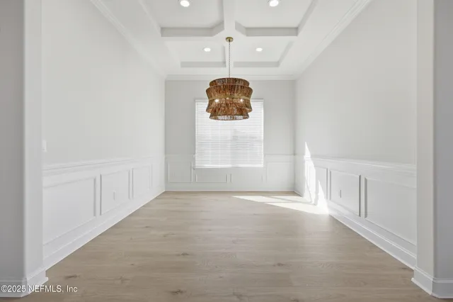 an empty room with windows and chandelier