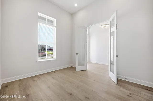 an empty room with wooden floor and windows