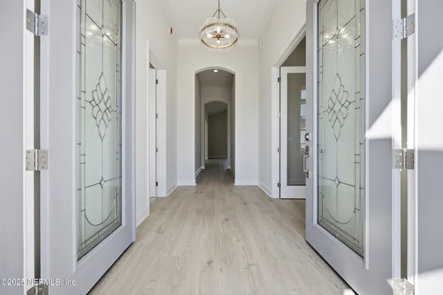 a view of a hallway with wooden floor and door