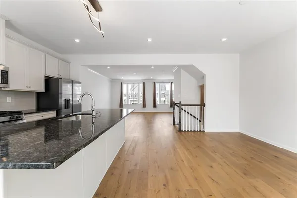 a view of a kitchen with kitchen island a counter top space a sink and stainless steel appliances