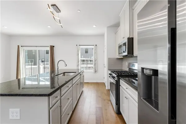 a kitchen with granite countertop a stove top oven sink and cabinets