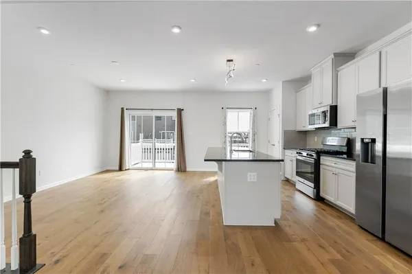 a large kitchen with cabinets wooden floor and stainless steel appliances