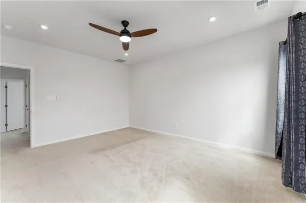 a view of a room with a ceiling fan and window