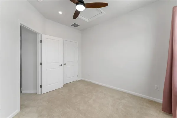 an empty room with a ceiling fan and a window