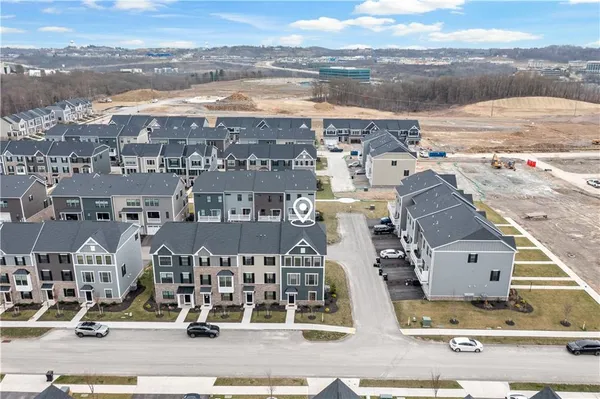 an aerial view of residential houses with outdoor space and ocean view