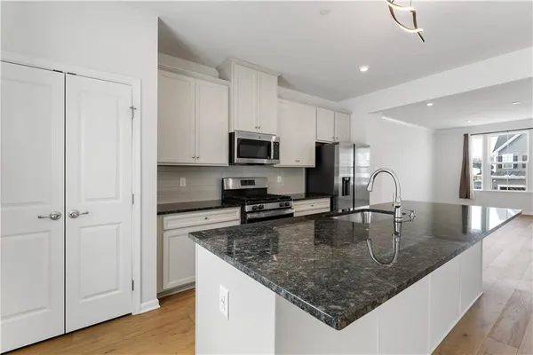 a kitchen with stainless steel appliances granite countertop a sink a stove and a center island