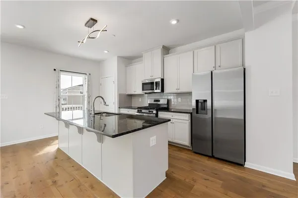 a kitchen with stainless steel appliances granite countertop a refrigerator a sink a stove a microwave and island