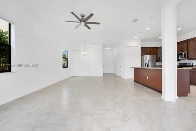 a living room with stainless steel appliances kitchen island furniture and a kitchen view
