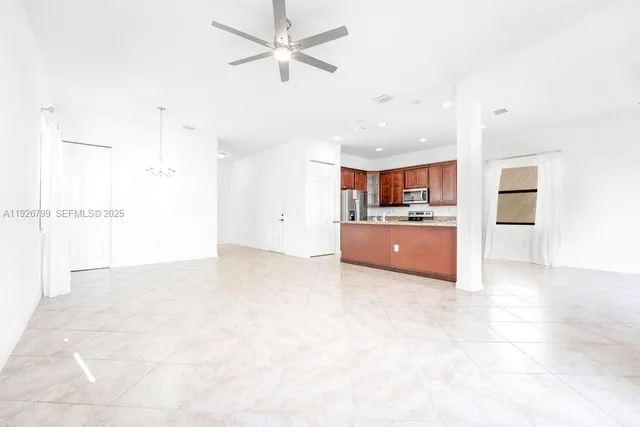 a large kitchen with stainless steel appliances kitchen island granite countertop a stove a sink a refrigerator and a microwave