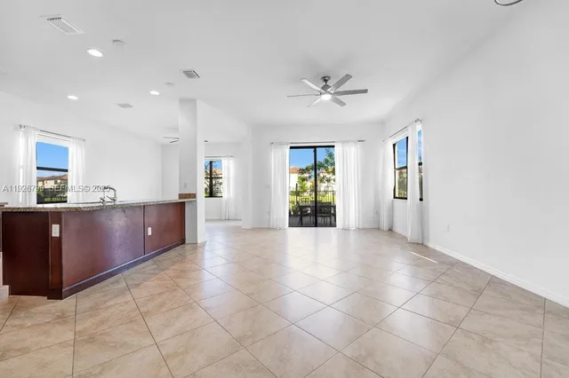 a large kitchen with stainless steel appliances kitchen island granite countertop a refrigerator and a sink