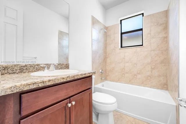 a view of a white house with a yard and potted plants