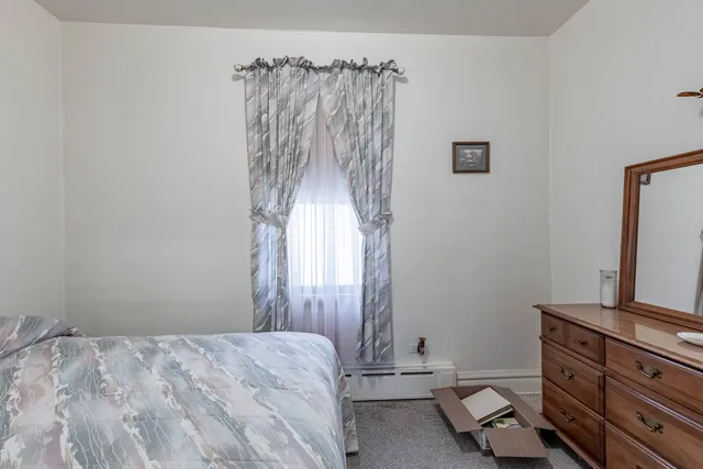 a bedroom with a bed and a flat tv screen on a dresser
