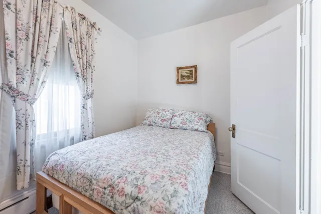 a bed sitting in a bedroom next to a window