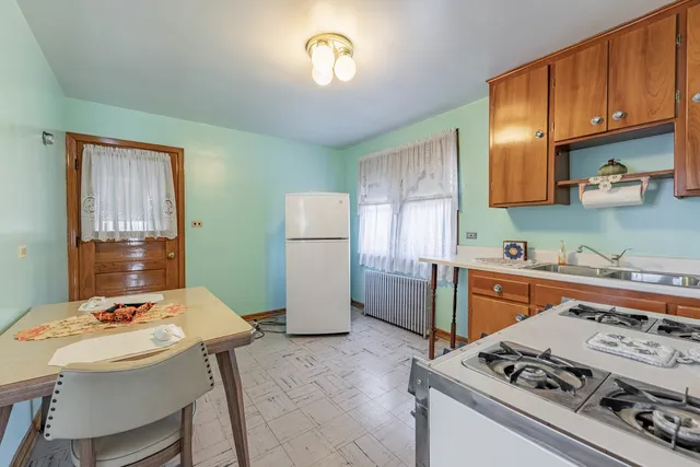 a kitchen with a stove a sink dishwasher and a refrigerator