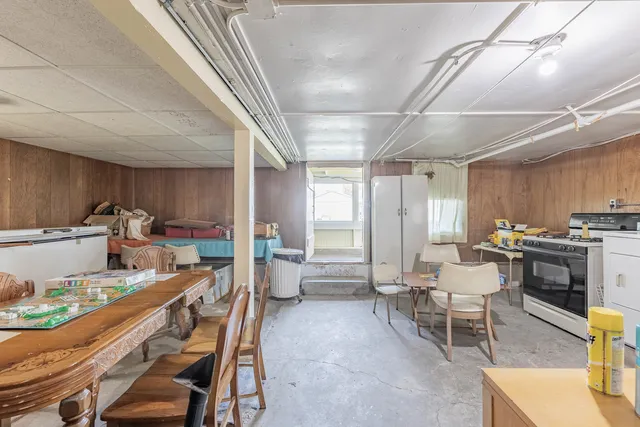 a room with stainless steel appliances kitchen island granite countertop a table chairs sink and cabinets