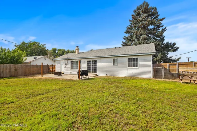 a view of a house with backyard and sitting area