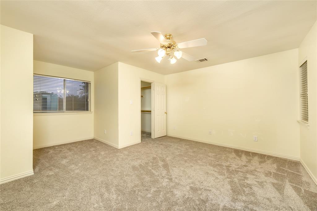 5801 Yeary Road Plano, TX 75093 - Photo 29 of 33 Carpeted room with a ceiling fan light fixture, two windows with blinds, and a built-in closet with shelving