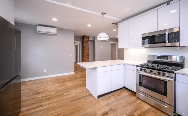 a large kitchen with stainless steel appliances granite countertop a stove a sink and a microwave