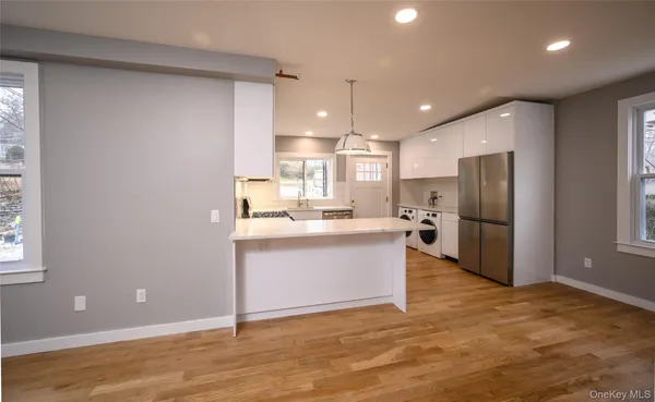 a view of kitchen with stainless steel appliances granite countertop a refrigerator and a sink