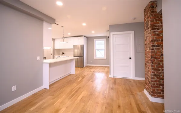 a view of a kitchen with wooden floor and electronic appliances