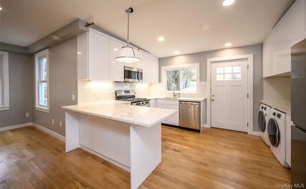 a kitchen with granite countertop a sink appliances cabinets and a counter top space