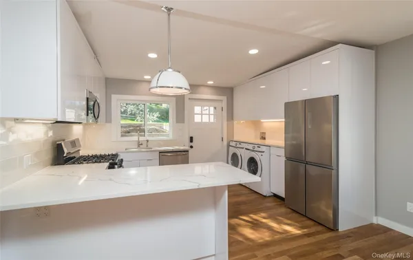 a kitchen with granite countertop a refrigerator oven a sink and cabinets