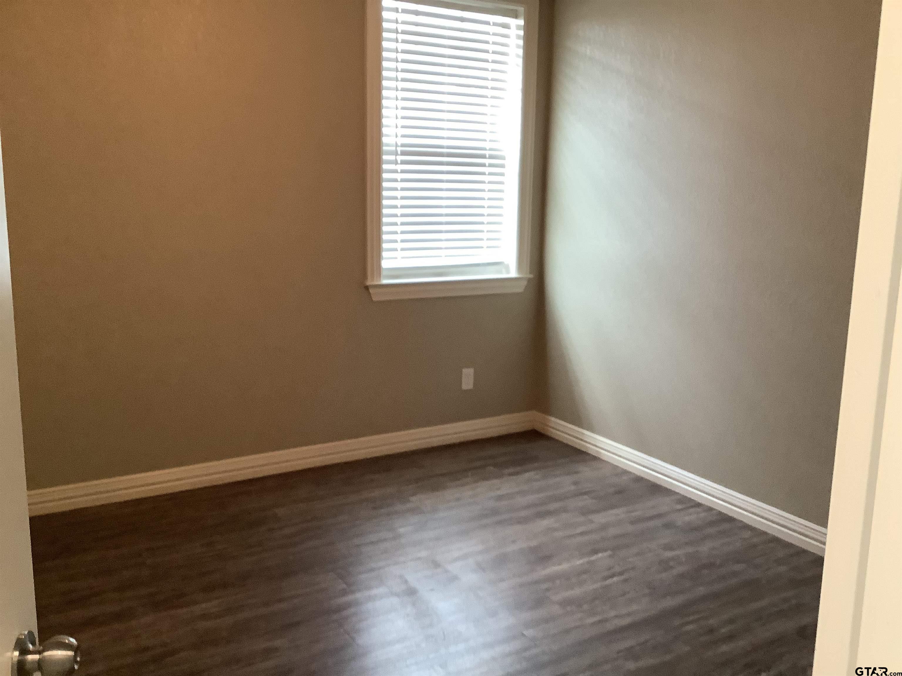 11621 FM 848 Tyler, TX 75707 - Photo 11 of 15 an empty room with wooden floor and windows