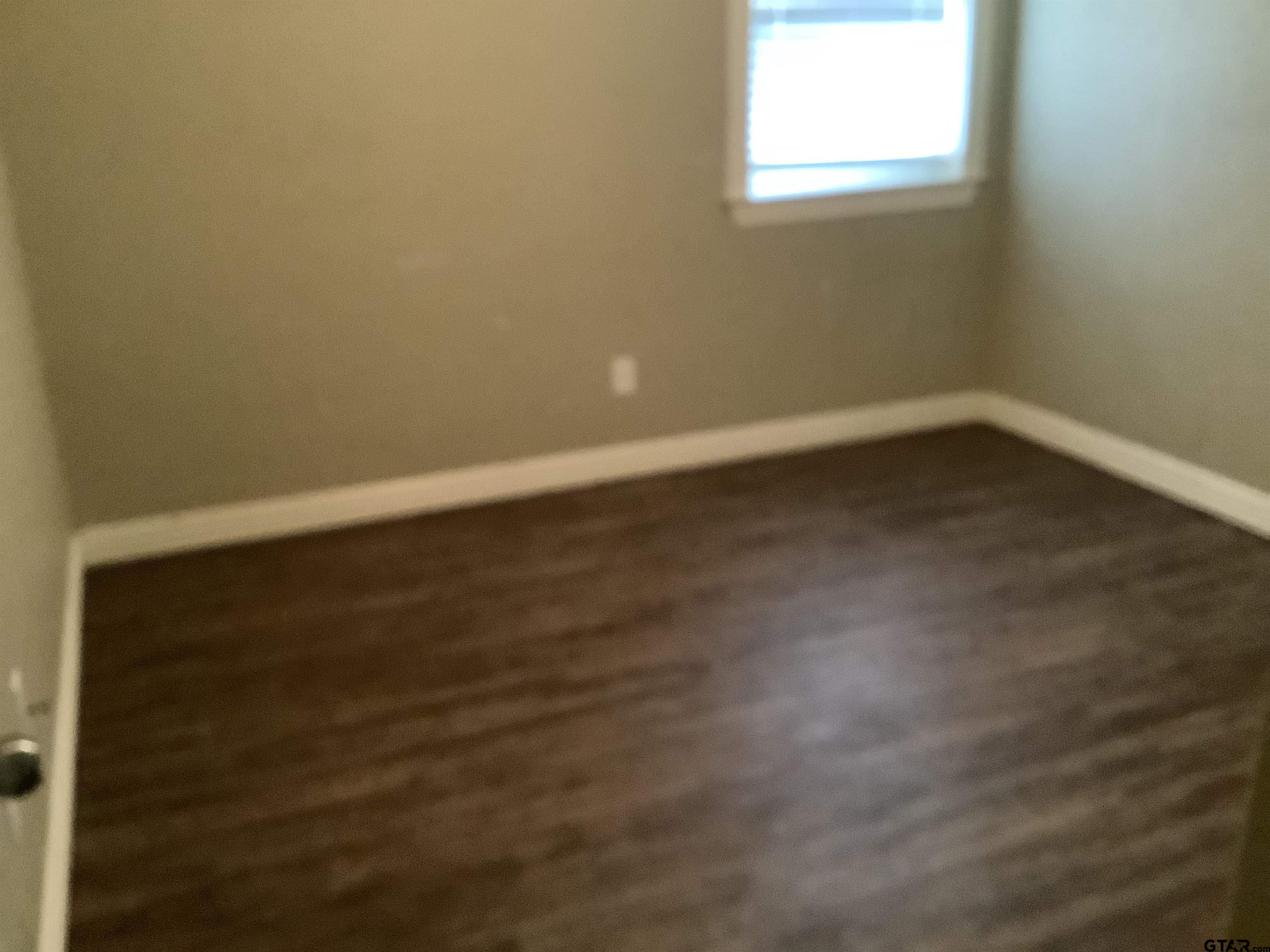 11621 FM 848 Tyler, TX 75707 - Photo 6 of 15 a view of an empty room with wooden floor and a window