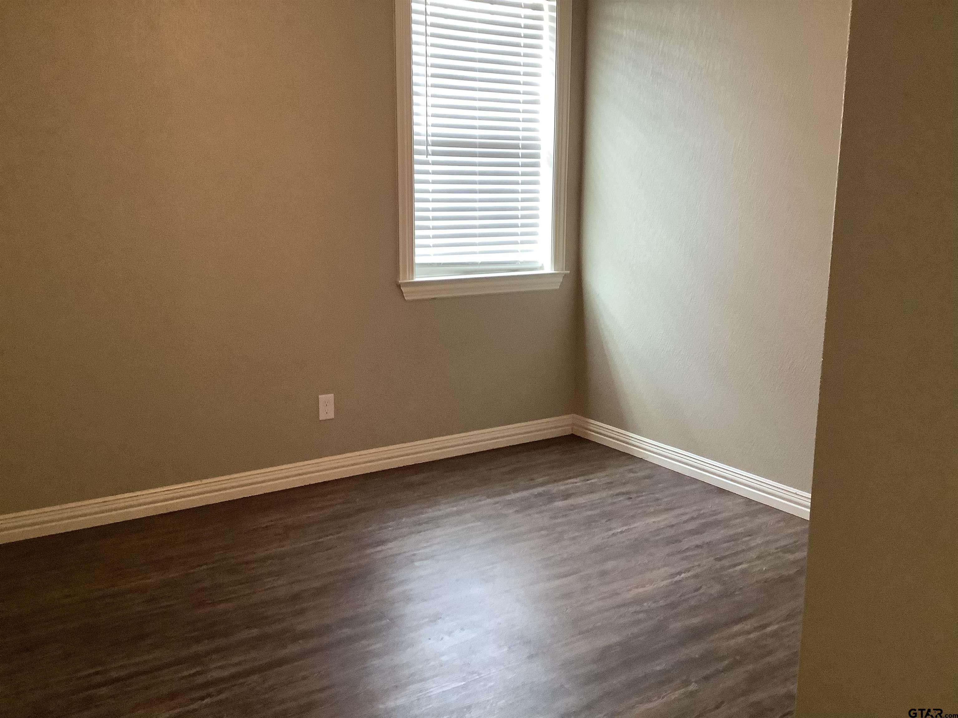 11621 FM 848 Tyler, TX 75707 - Photo 9 of 15 a view of an empty room with wooden floor and a window