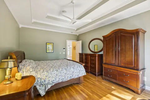 a bedroom with a bed a dresser and potted plants