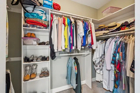 a view of walk in closet with clothes and shoes