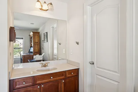 a bathroom with a granite countertop sink and a mirror