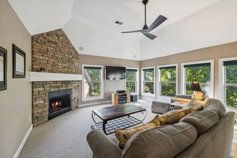 a living room with furniture large window and a fireplace