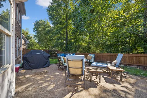 a view of a patio with table and chairs and potted plants