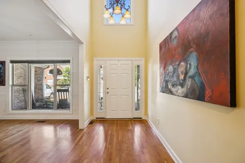 a view of a hallway with wooden floor and a window