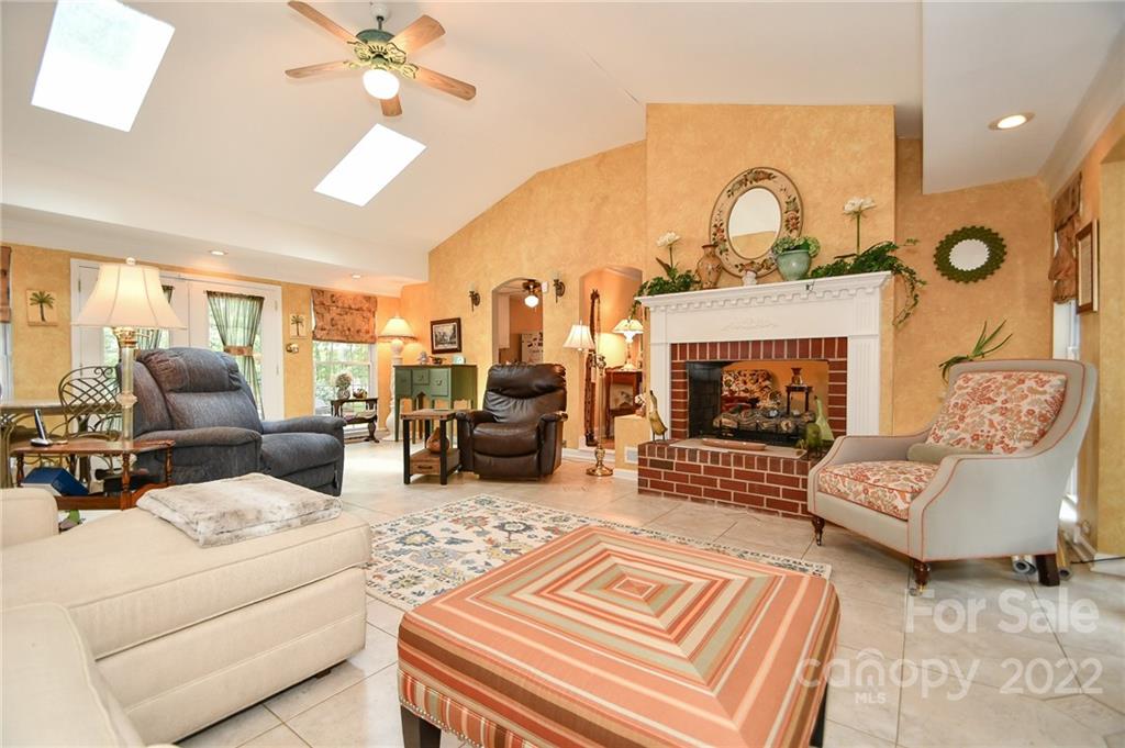 9101 Bartlett Road Mint Hill, NC 28227 - Photo 13 of 20 a living room with furniture a fireplace and a chandelier
