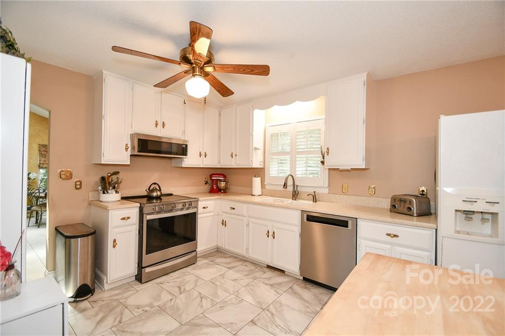 9101 Bartlett Road Mint Hill, NC 28227 - Photo 10 of 20 a kitchen with a sink cabinets stainless steel appliances and a window