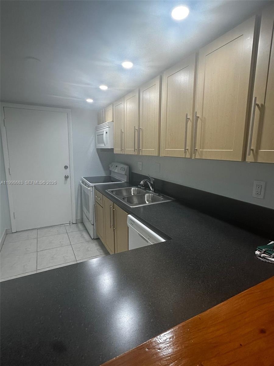 8101 Southwest 73rd Avenue, Unit 1 Miami, FL 33143 - Photo 5 of 52 a kitchen with stainless steel appliances a stove a refrigerator a sink a counter top space and cabinets
