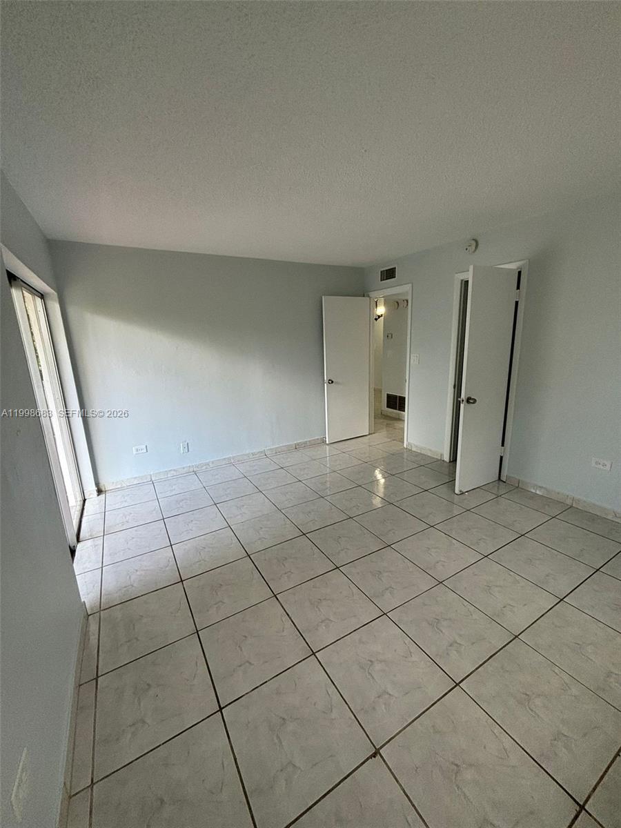 8101 Southwest 73rd Avenue, Unit 1 Miami, FL 33143 - Photo 8 of 52 an empty room with a fireplace and cabinet