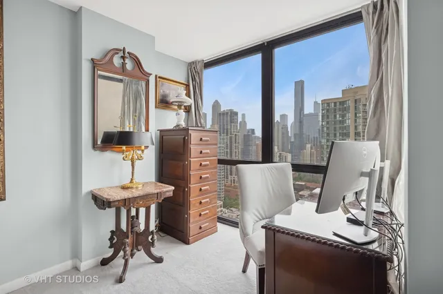 a view of a workspace with furniture and a window